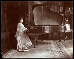 Mevrouw I. M. Clark zittend aan een vleugelpiano, 1904